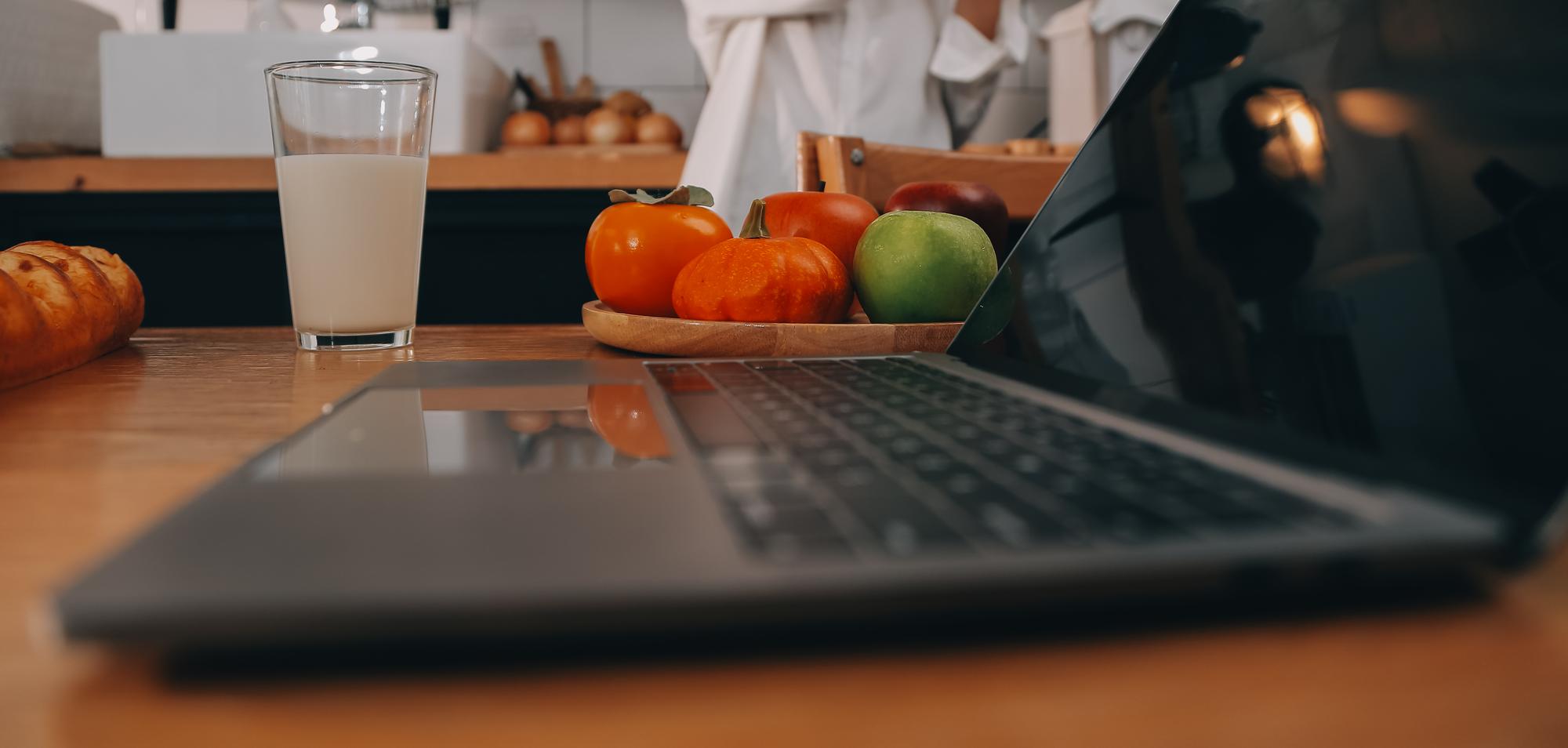 Workspace cucina minimal con laptop e ingredienti